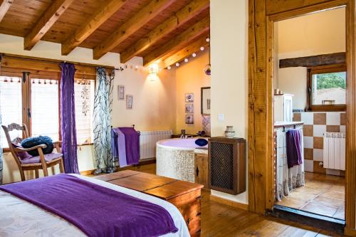 a bedroom with a bed and a tub in a room at La Tarabilla in Casas del Abad