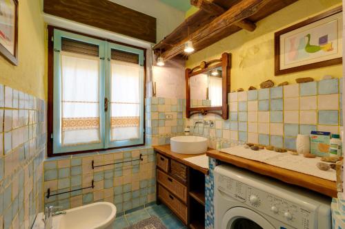 a bathroom with a sink and a washing machine at Paolo e Francesca in Bosa Marina