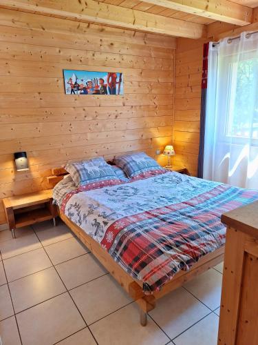 a bedroom with a bed in a log cabin at Le Refuge - Faucigny in Faucigny