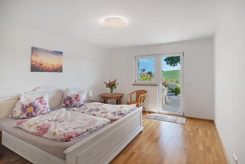 a white bedroom with a bed and a window at Fewo Landschaftstraum am Bodensee in Lindau
