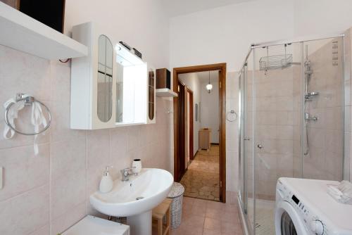 a white bathroom with a sink and a shower at La Casa Della Gioia - Serravalle in Serravalle Scrivia