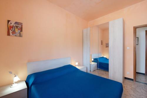 a bedroom with a blue bed and a mirror at La Casa Della Gioia - Serravalle in Serravalle Scrivia