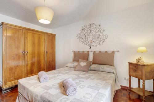 a bedroom with a bed and a wooden cabinet at Appartamento Delfine in La Salle