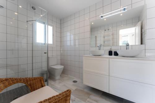 a white bathroom with two sinks and a toilet at Holiday Villa Torrenueva in La Cala de Mijas