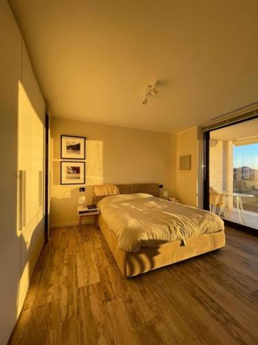 a bedroom with a large bed and a large window at Italian Heaven in Perledo