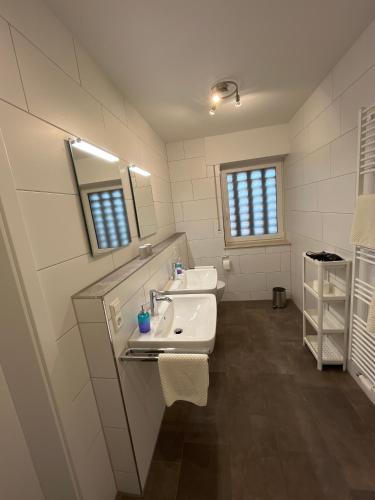 ein weißes Badezimmer mit Waschbecken und Spiegel in der Unterkunft Seeblick in Versmold