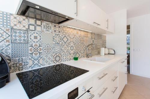 a kitchen with a sink and a tiled wall at Villa Jodie in Sóller