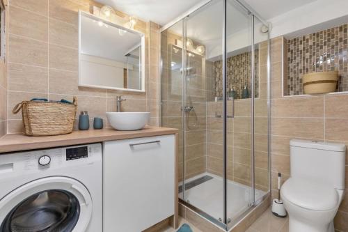 a bathroom with a washing machine and a shower at Appartement Pinède in Cap d'Agde