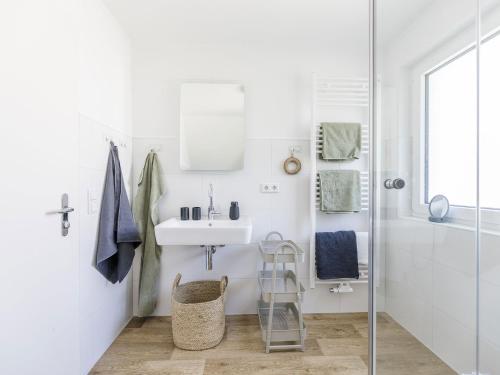 a white bathroom with a sink and a shower at Dorfhaus1953 in Eslohe