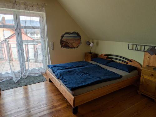 a bedroom with a bed and a large window at Ferienwohnung Dorfprozelten in Dorfprozelten