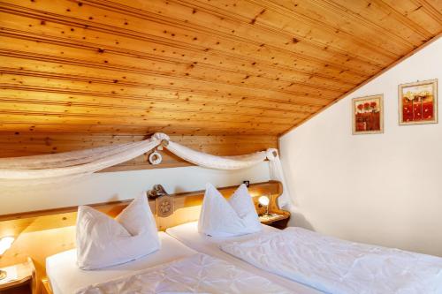 a bedroom with two beds and a wooden ceiling at Ferienhaus St Christoph in Mittenwald