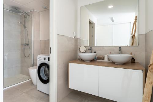 a bathroom with two sinks and a washing machine at Luxury Penthouse with Rooftop in Fuengirola