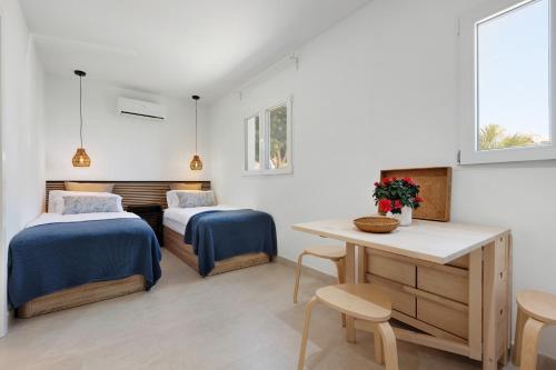 a bedroom with two beds and a table and chairs at La Lajita Beach Estudio in Lajita