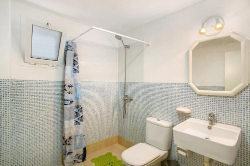 a bathroom with a toilet and a sink and a mirror at Rach Agaete in Agaete