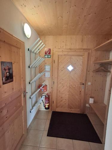 a hallway with a wooden door and a black rug at Chalet Martina in Stadl an der Mur