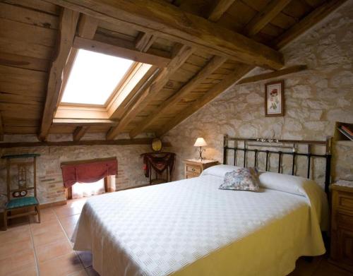 ein Schlafzimmer mit einem großen Bett und einem Dachfenster in der Unterkunft Las Espigas in Canalejas de Peñafiel