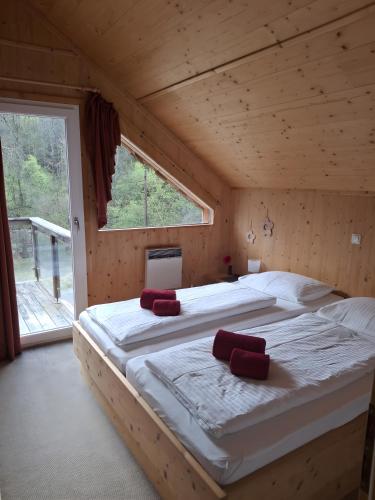 two beds in a wooden room with a window at Chalet Martina in Stadl an der Mur