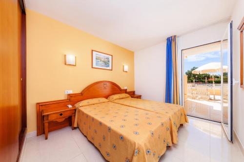 a bedroom with a bed and a large window at Apartamento Espiga in Cala Bona