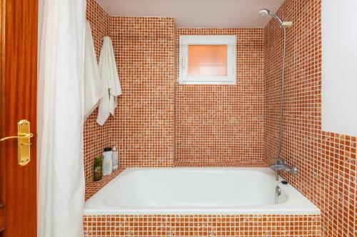 a bathroom with a tub in a tiled shower at Apartamento Espiga in Cala Bona