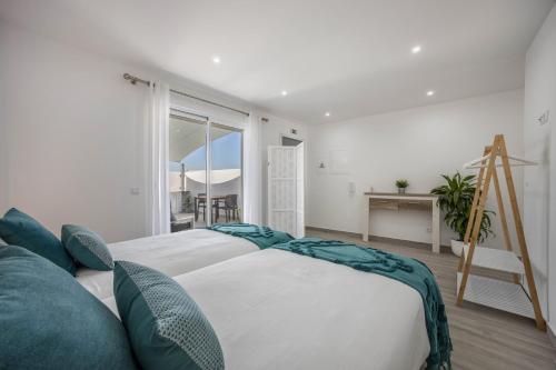 a bedroom with a bed and a desk and a window at Sunset Apartment in Sagres