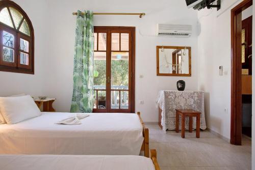 a bedroom with a bed and a table and a window at Areti Orfeas Apartment 3 in Vasilikos