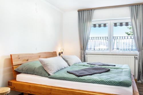 a bed in a room with a window at Fewo Kleinert in Billingsbach