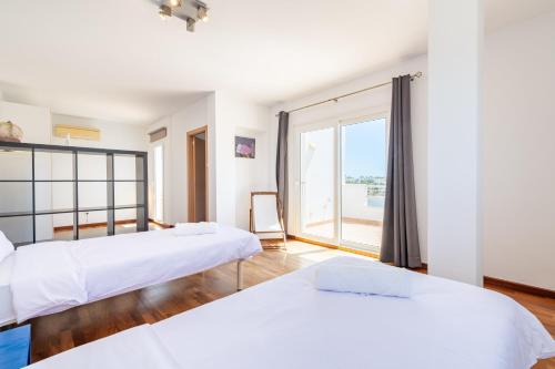 a bedroom with two beds and a large window at Casa La Siesta in Cala d´Or