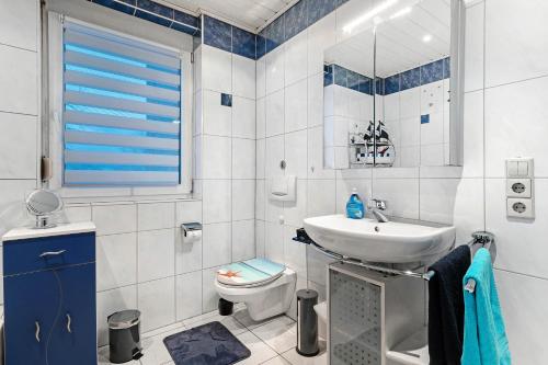 a white bathroom with a sink and a toilet at Ferienwohnung Rheinvorland in Linx