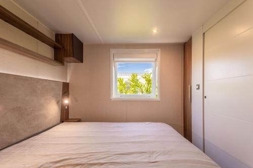 a bedroom with a bed and a window at Le Mediterranéen in Fréjus