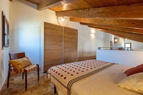 a bedroom with a large bed and a chair at La Casa di Valverde in Alghero