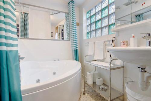 a white bathroom with a tub and a sink at Casa Armando in Laglio