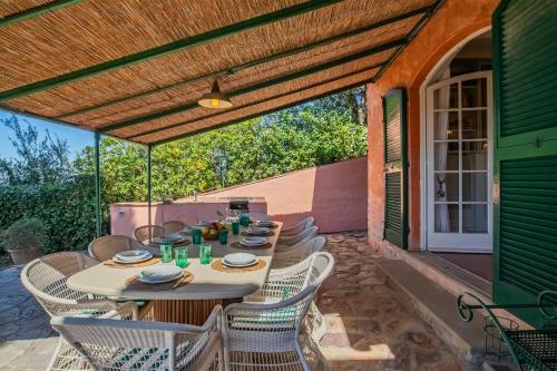 a patio with a table and chairs under a pergola at Villa Les Ombrelles in Portoferraio