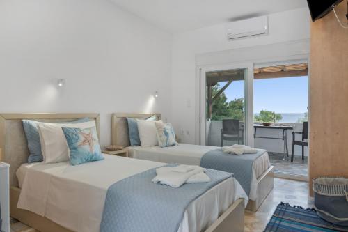 a bedroom with two beds and a view of the ocean at Niki's Studios Kalymnos in Kalymnos