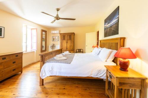 a bedroom with a large bed and a table at Maison Vigneronne-piscine et vignes in Trèbes