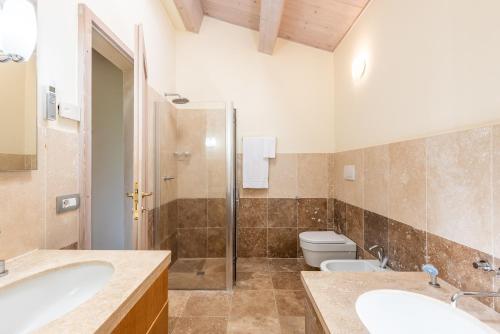 a bathroom with two sinks and a toilet at Villa Falco in Trequanda