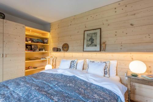 a bedroom with a bed with wooden walls at Haus Alpenveilchen - Appartement 3 in Schönau am Königssee