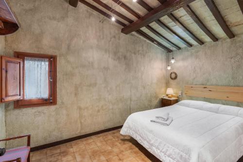a bedroom with a large white bed in a room at Cal Cisteller in Olvan