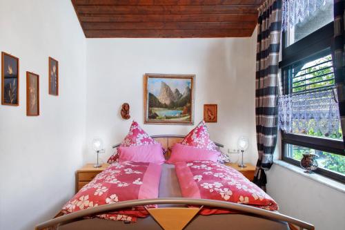a bedroom with a bed with pink pillows at Ferienwohnung Schindele in Langenargen