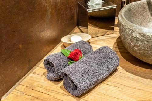 a grey towel with a red rose on top of it at Chalet Hüttentraum in Inzell
