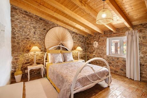 a bedroom with a bed and a stone wall at Quinta do Silêncio T2 in Tavira