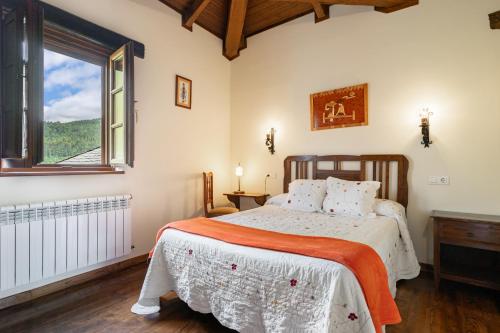 ein Schlafzimmer mit einem Bett und einem großen Fenster in der Unterkunft Maseda 2 in Villayón