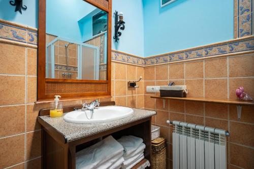 ein Badezimmer mit Waschbecken und Spiegel in der Unterkunft Maseda 2 in Villayón