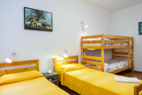 two beds in a room with two bunk beds at Trilo Begonia in Marina di Grosseto