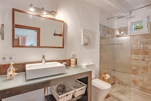 a bathroom with a sink and a toilet and a mirror at Ca les Estamenyes in Pollença