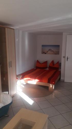 a bedroom with a bed with red pillows on it at Ferienwohnungen Hiddenseeblick 3 in Dranske