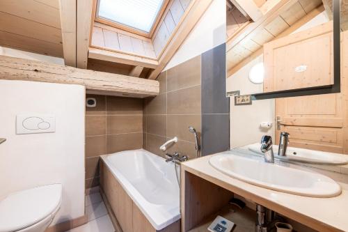 a bathroom with a sink and a tub and a toilet at Le Galetas in Brides-les-Bains