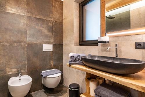 a bathroom with a black sink and a toilet at Blosegghof Bergchalets Talblick in Racines