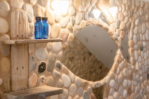 a mirror in a bathroom with a rock wall at Green Retreats 4 Paros in Isterni