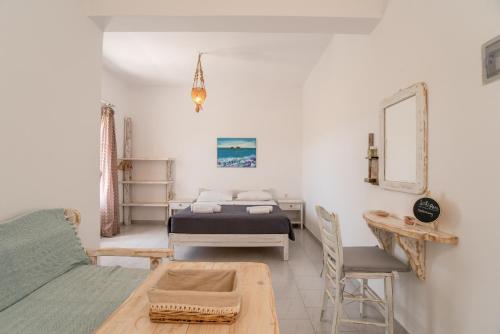 a bedroom with a bed and a couch and a table at Green Retreats 4 Paros in Isterni