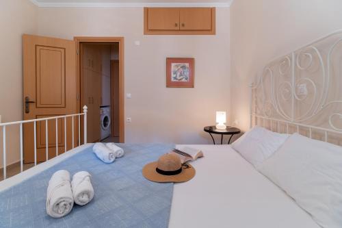 a bedroom with a bed with a hat and towels on it at Villa Votistis A1 in Lefkada